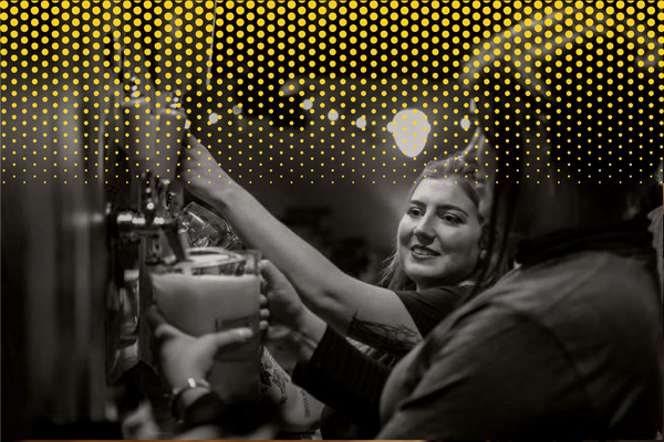 Black and white image of two women pouring beer at Candid Brewing Company.