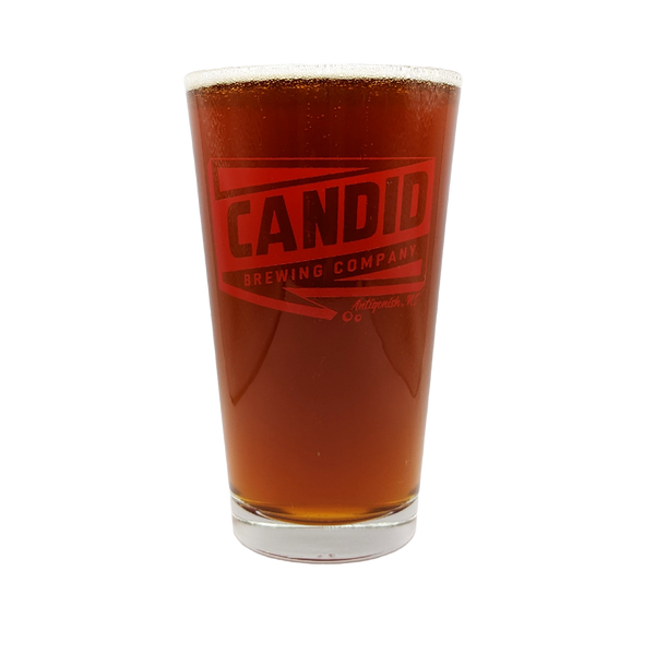 A pint of Candid's Humdinger West Coast IPA in a Candid branded pint glass. 