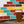 Load image into Gallery viewer, A Candid branded pint glass filled with Humdinger beer and in front of a brock wall painted red, blue, brown and yellow.
