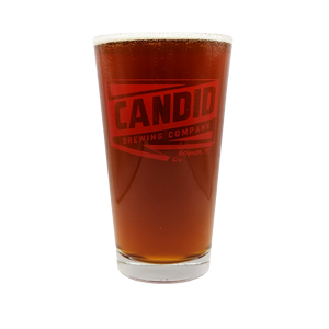 A pint of Candid's Humdinger West Coast IPA in a Candid branded pint glass. 